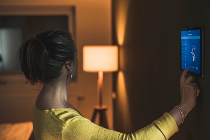 A person dimming a lamp using a smart home hub.