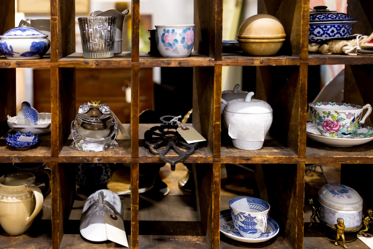 Square shelves holding vintage dinnerware and gifts for sale.