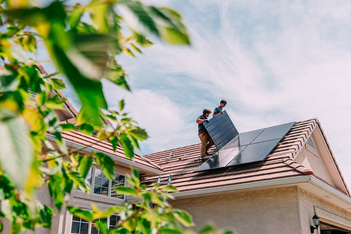 Contractors installing solar panels on a residential home.