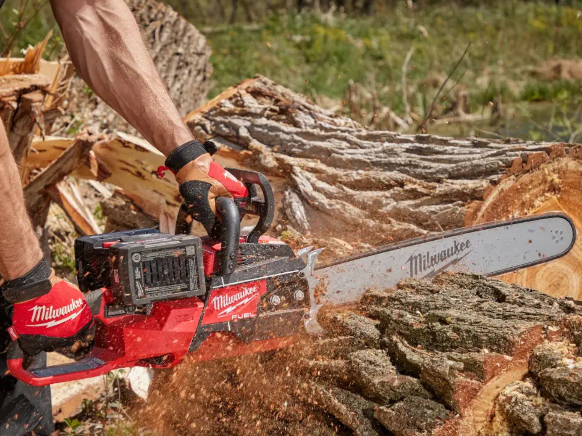 Person cutting tree trunk into slices with a Milwaukee battery chainsaw