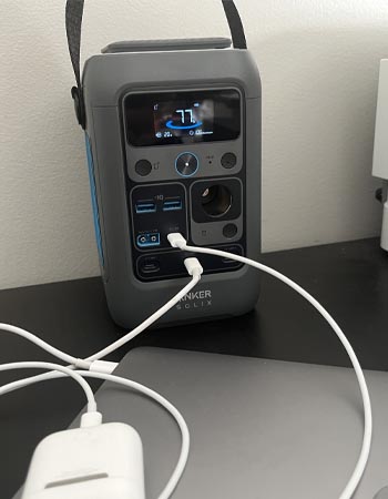 Anker Solix C300 DC Portable Power Station on floor with laptop and airpods charging