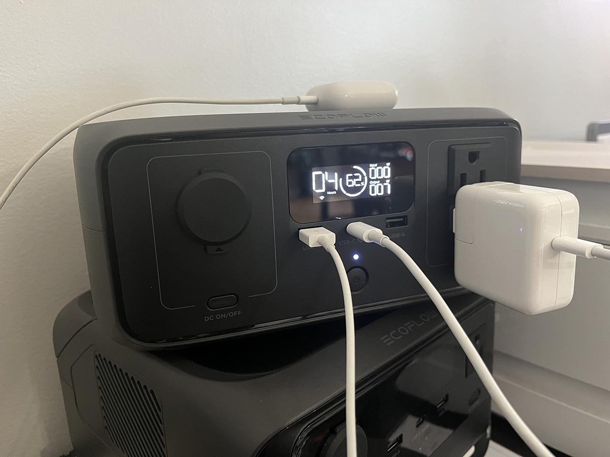 Airpods and laptop charging cable plugged into the EcoFlow River 3