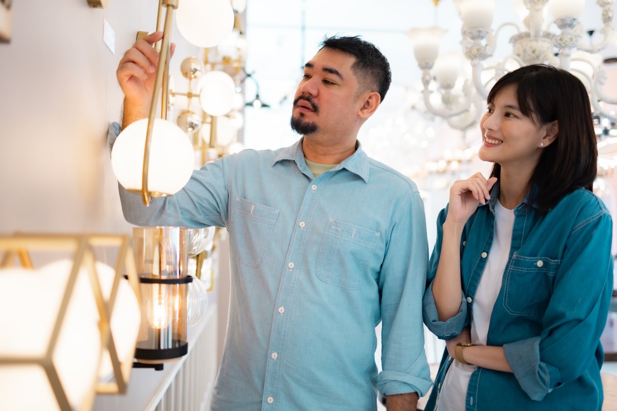 Couple at a lighting store looking at different light fixture options.