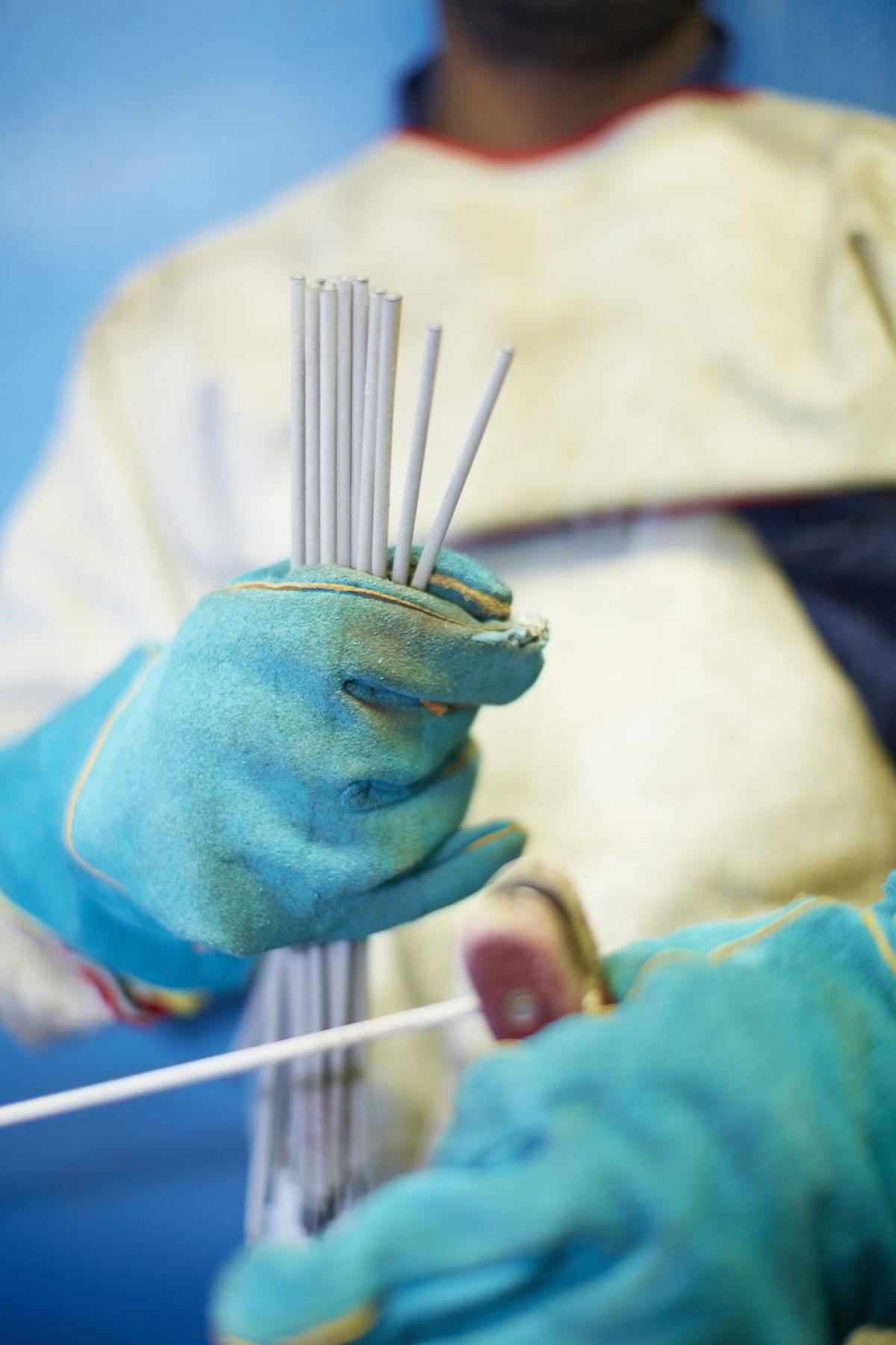 A welder holding up electrode rods for stick welding in the garage.