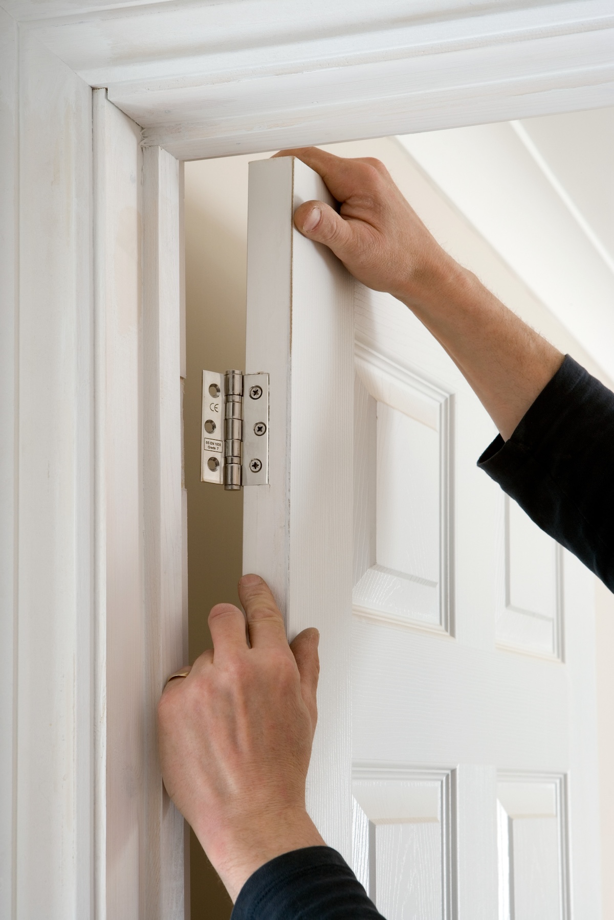 A person installing an interior door.