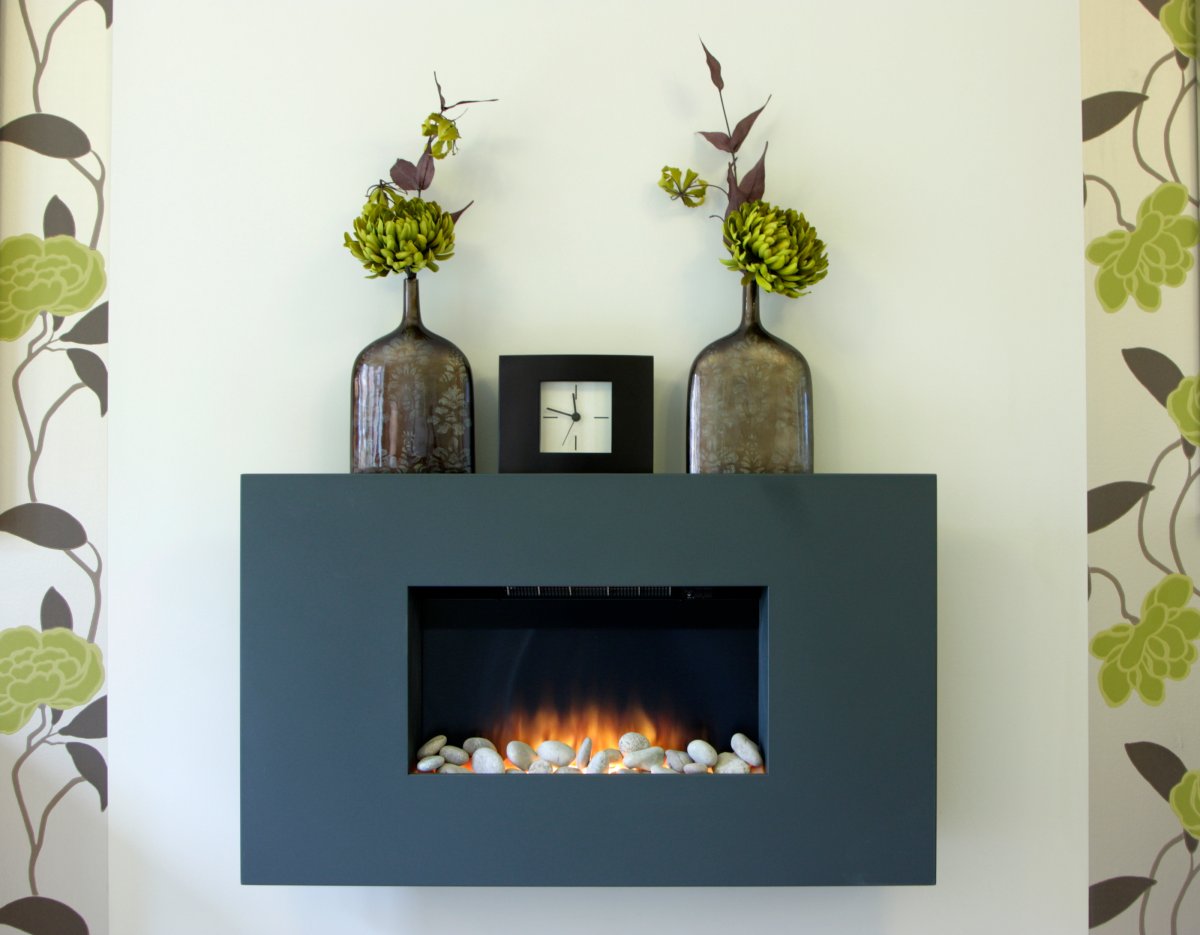 A modern gas fireplace with a control panel installed in a living room.