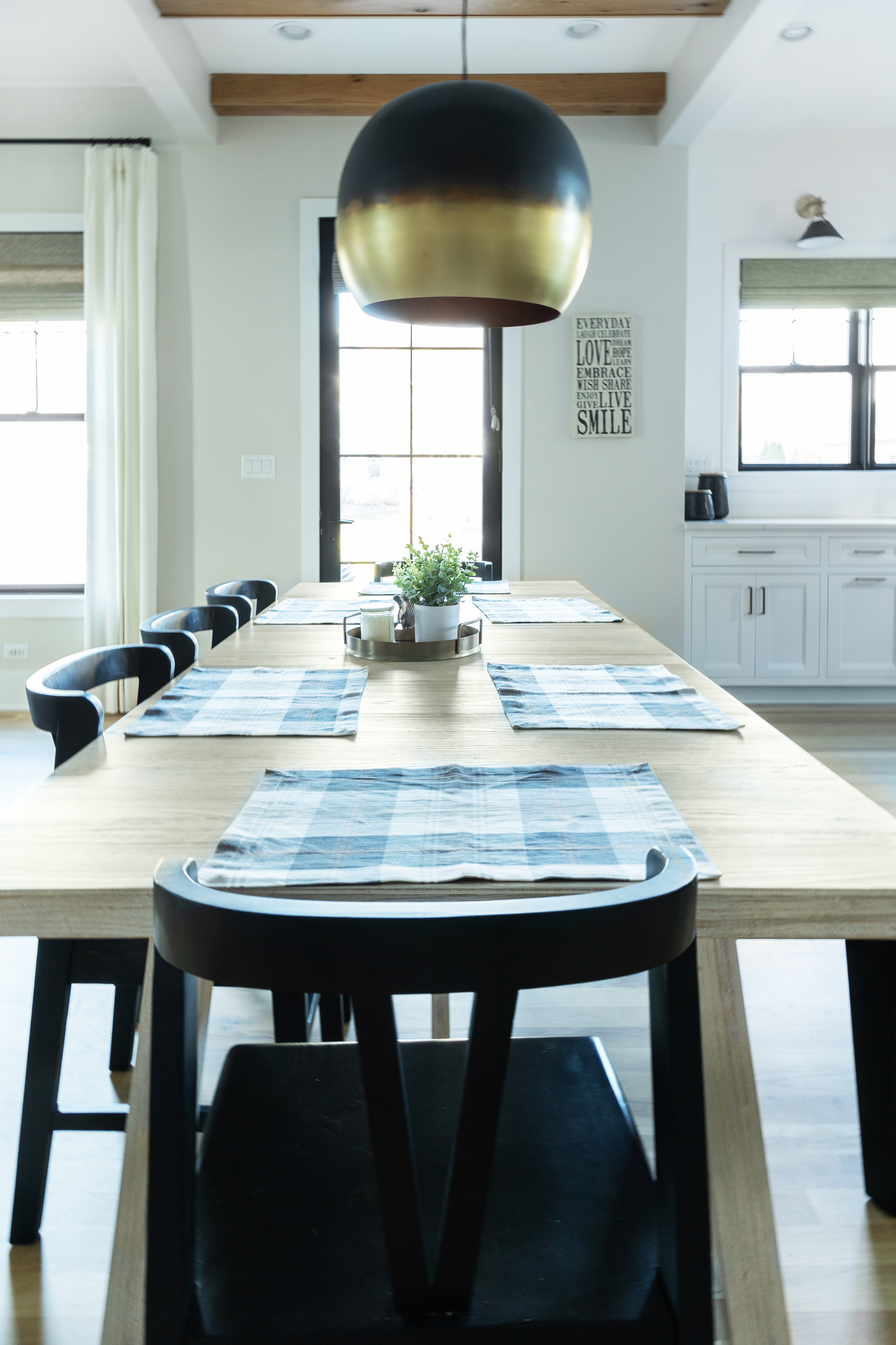 A large pendant light hanging over a dining table in a kitchen.