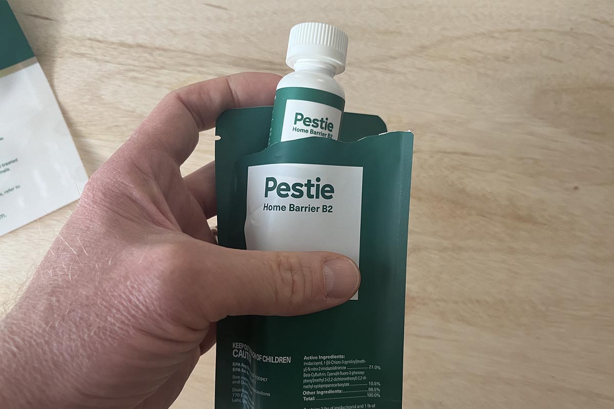 Hand holding Pestie Home barrier 2 insecticide concentrate