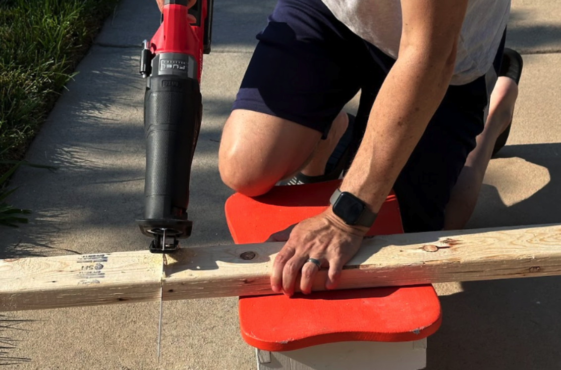 Person using a Bosch reciprocating saw to cut through wood