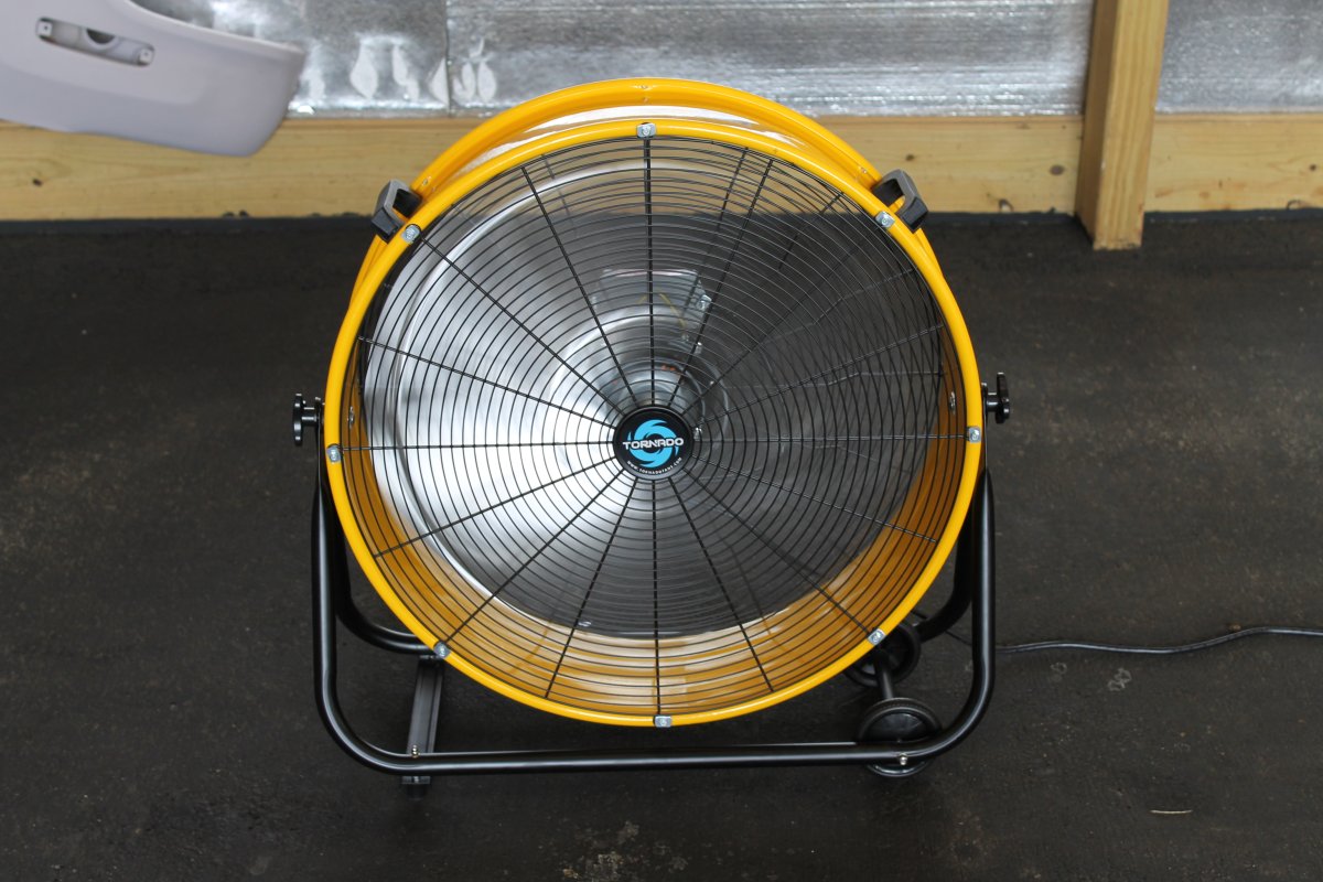 Tornado 24 High-Velocity Metal Tilt Drum Fan set up in a garage