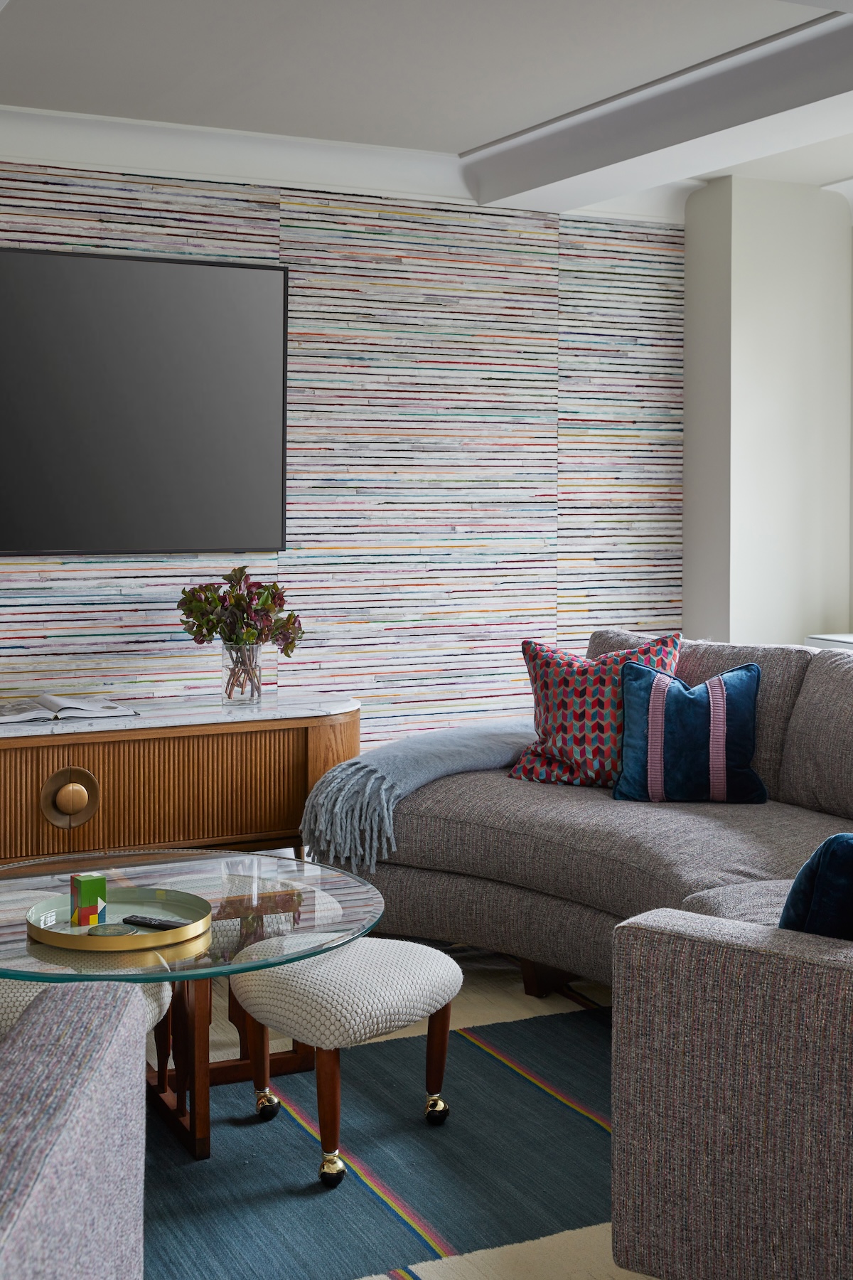 Traditional striped wallpaper installed on a living room accent wall.