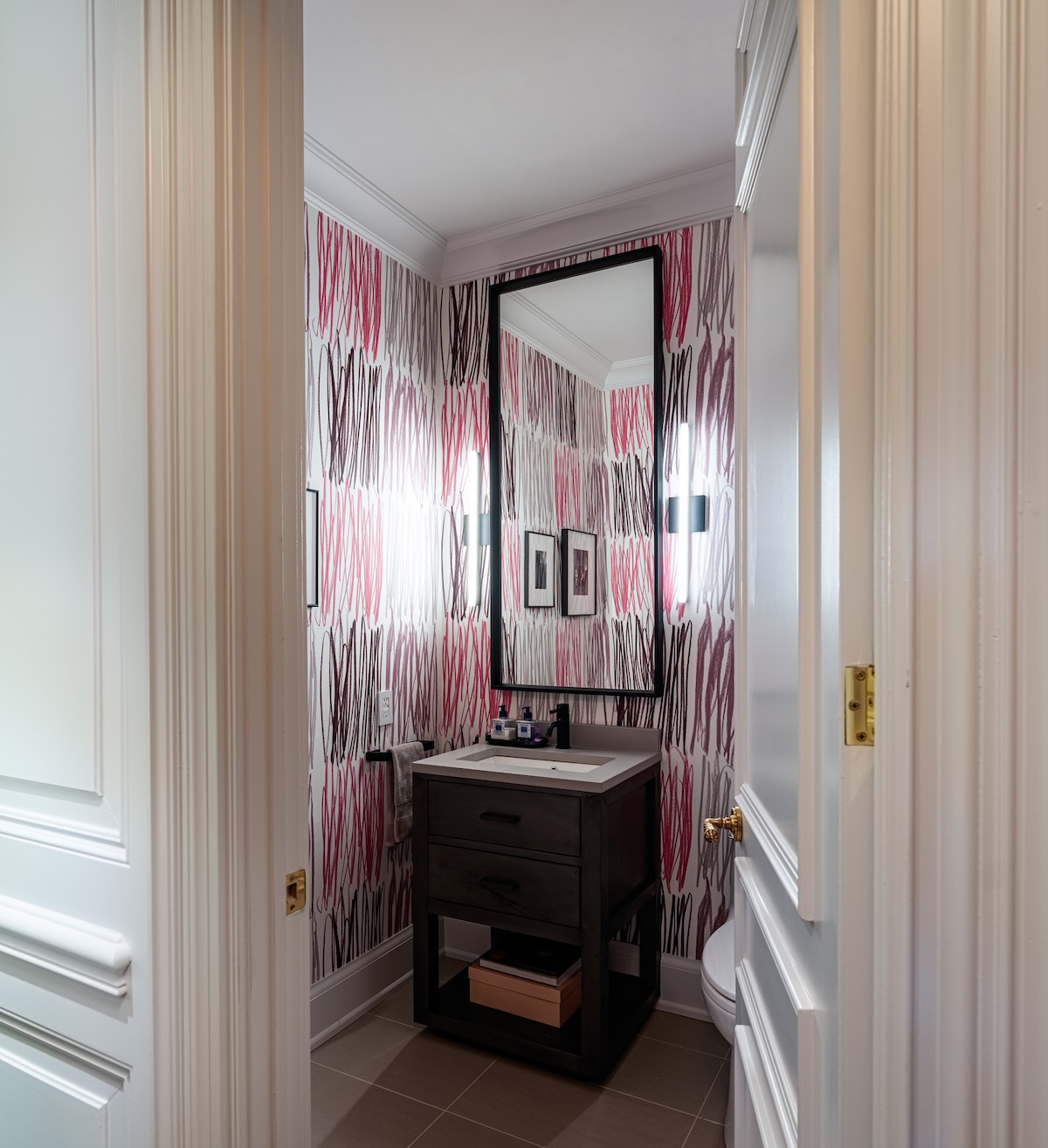 A small powder room decorated with wallpaper.