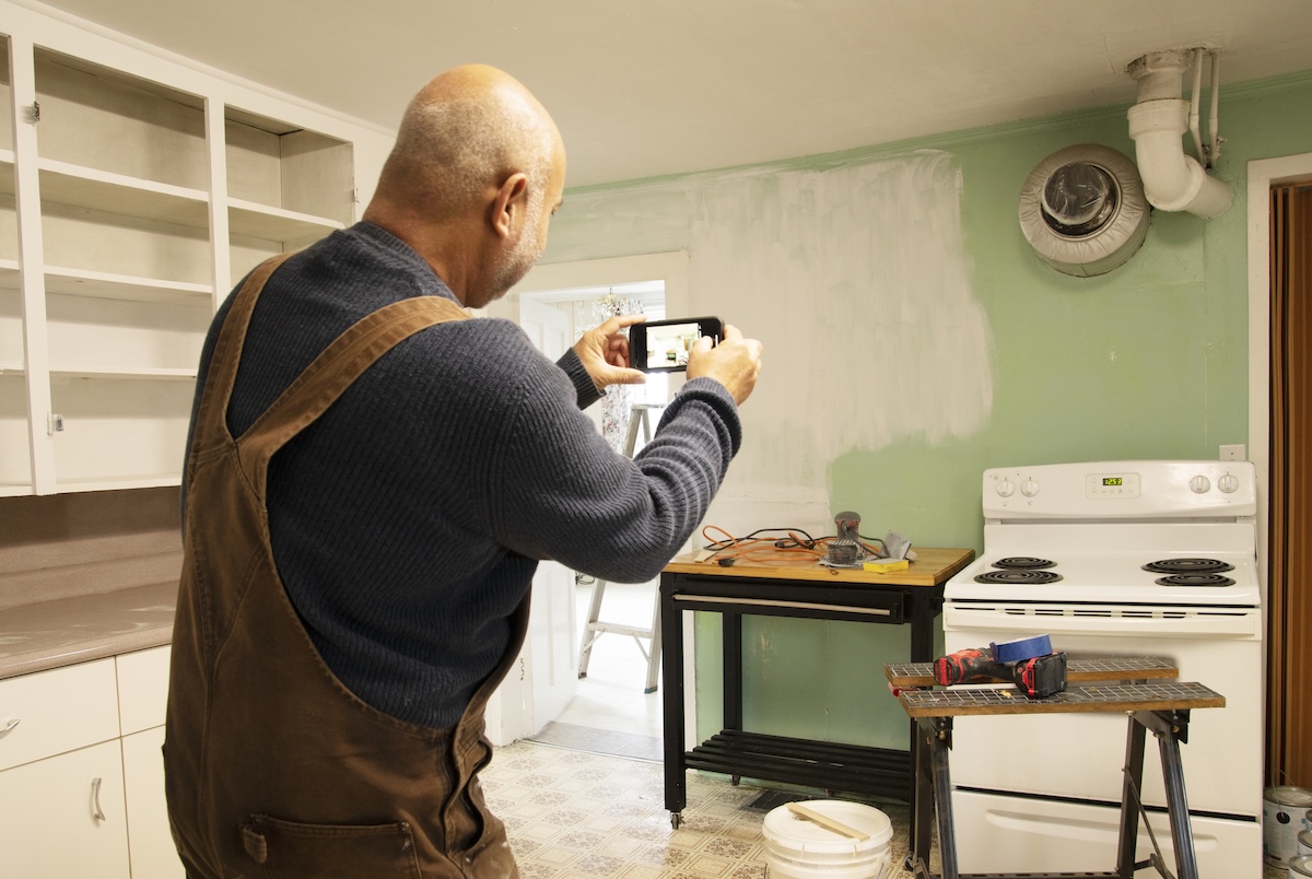 A DIYer taking photos of a renovation project in-progress.