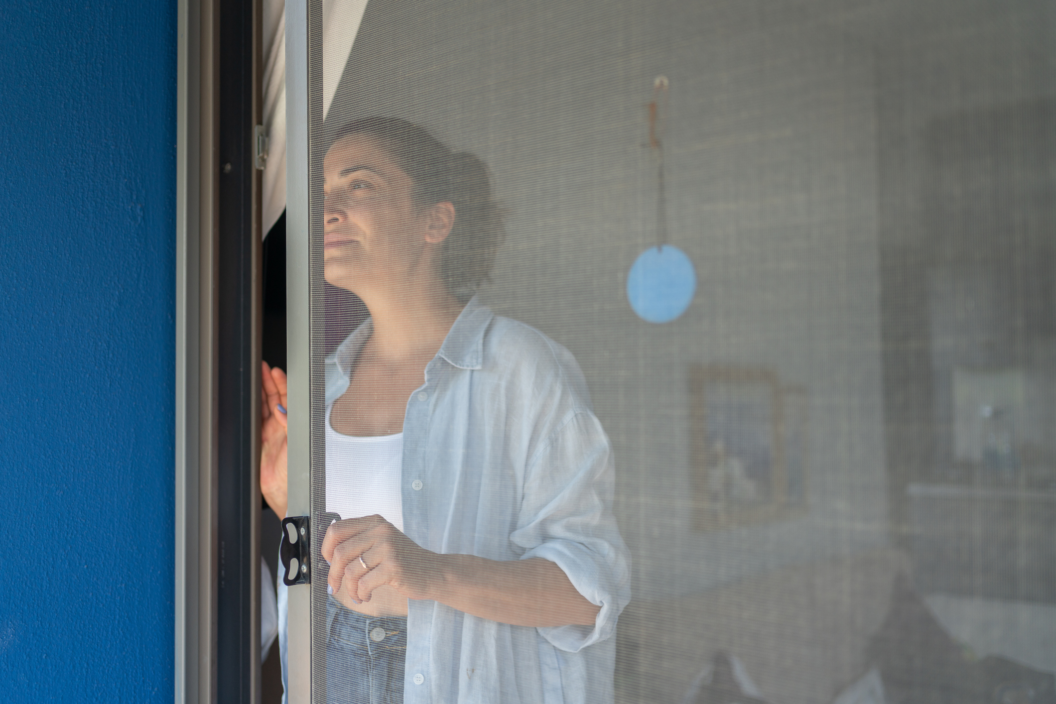 Woman Opening Mosquito Net Wire Screen Door At Home