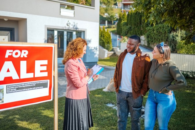 Woman realtor showing a house to a couple trying to buy a new home