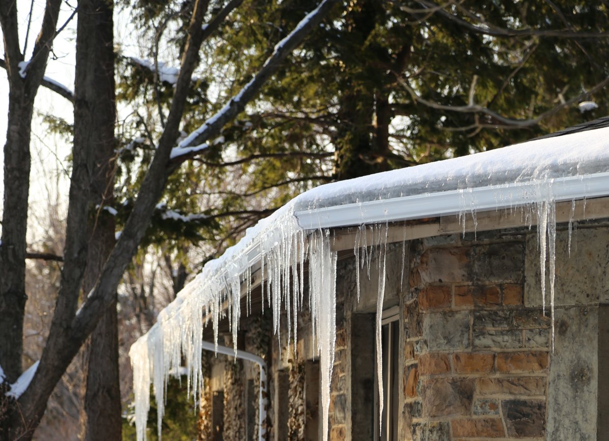 Brick house with snow and icicles on the gutter.