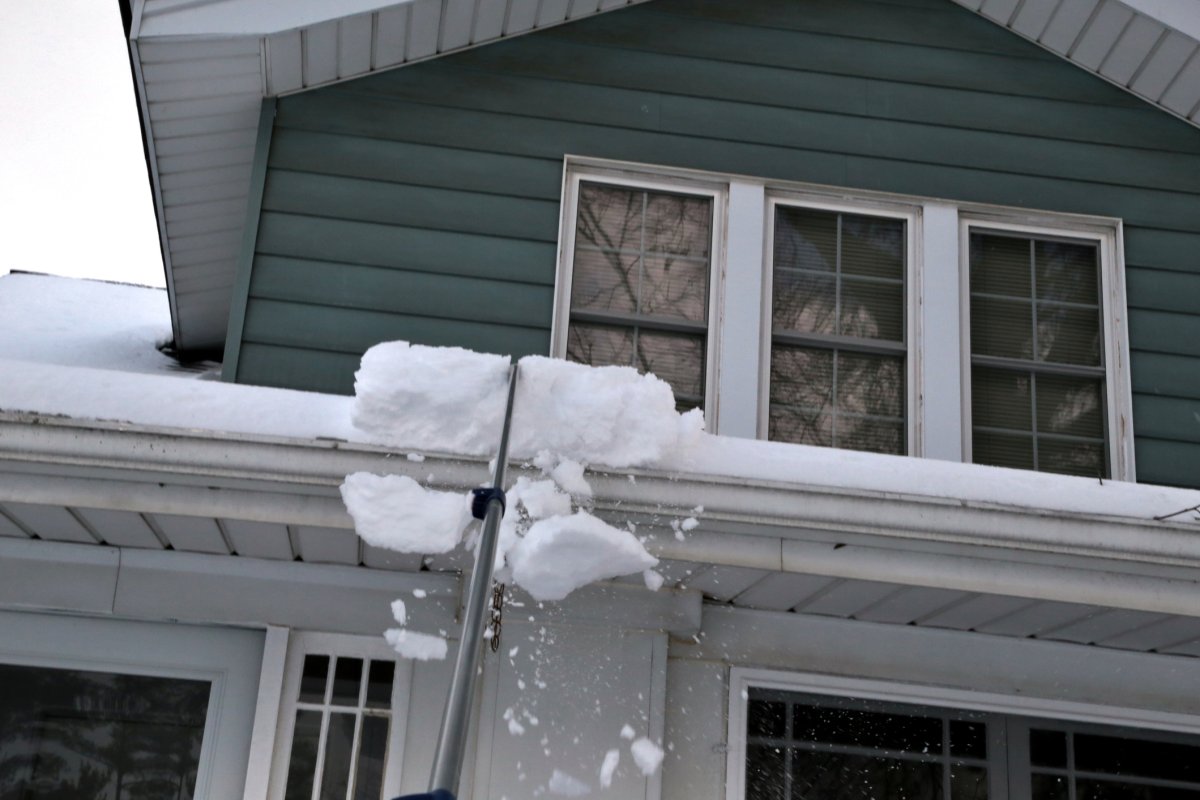 Snow roof rake clears the snow off of a house roof.