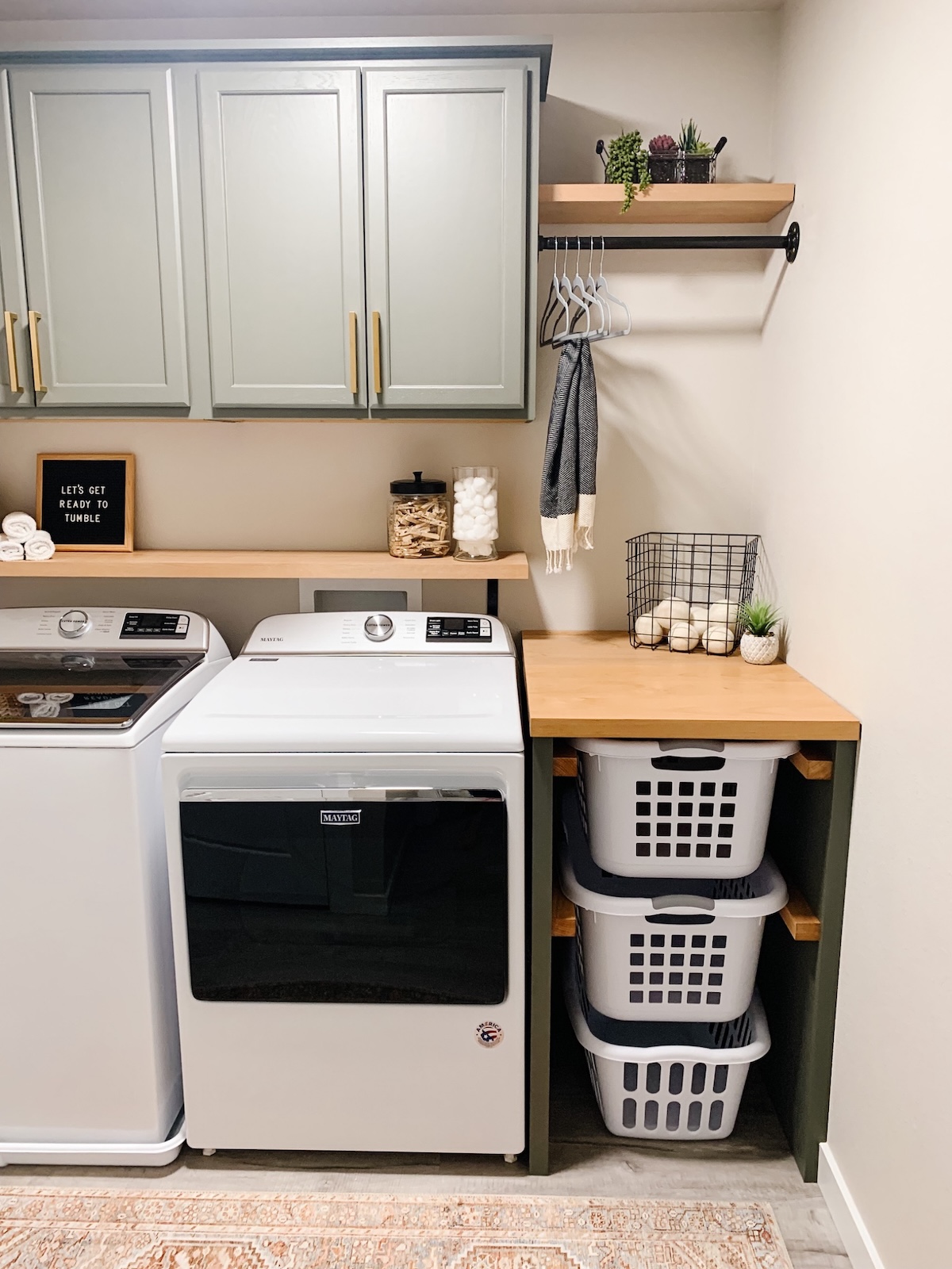 A laundry room with stock cabinet projects for storage.