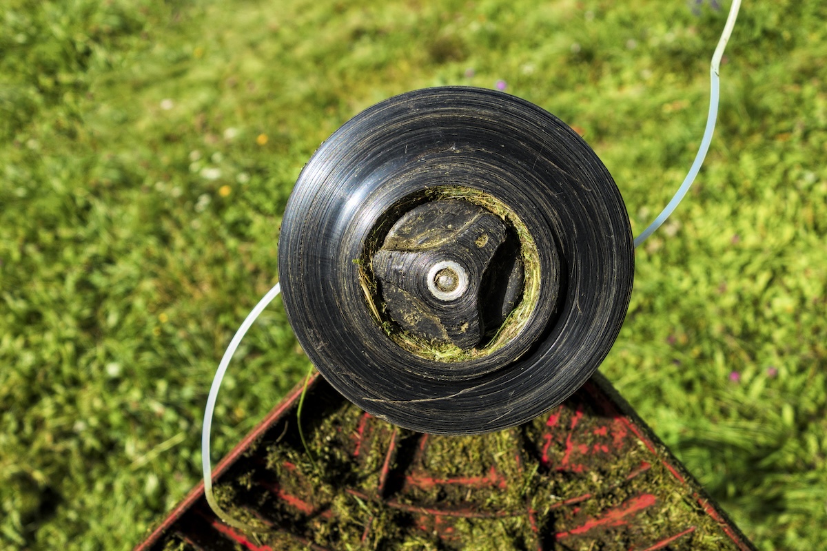 A close up of the spool on a weed eater.