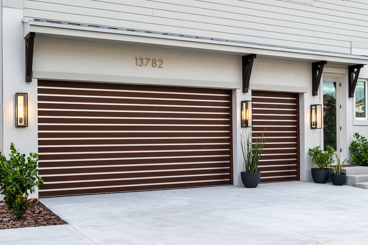 Modern garage doors with wooden panels and white exterior.