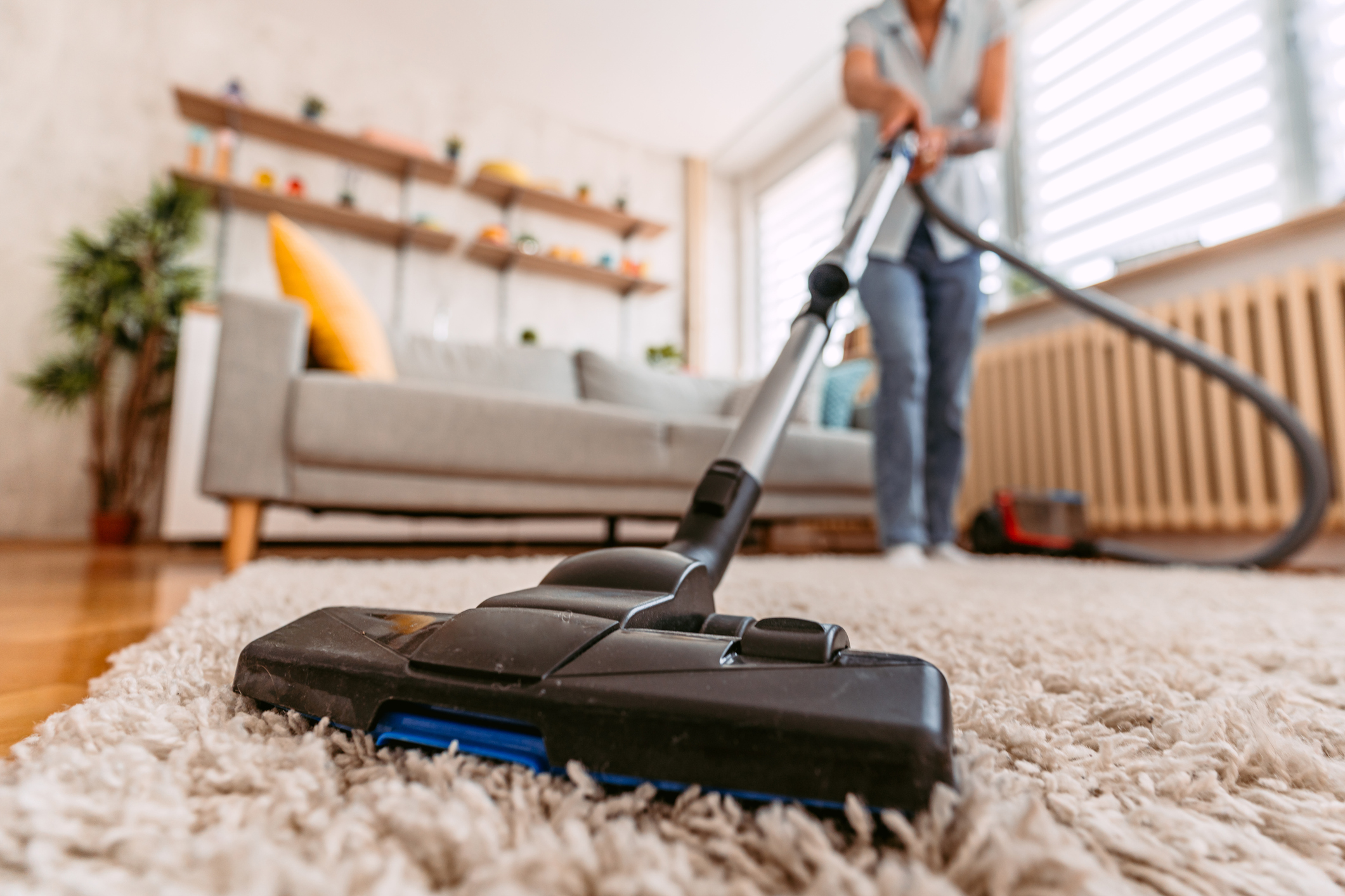 Woman vacuuming the carpet in her home.