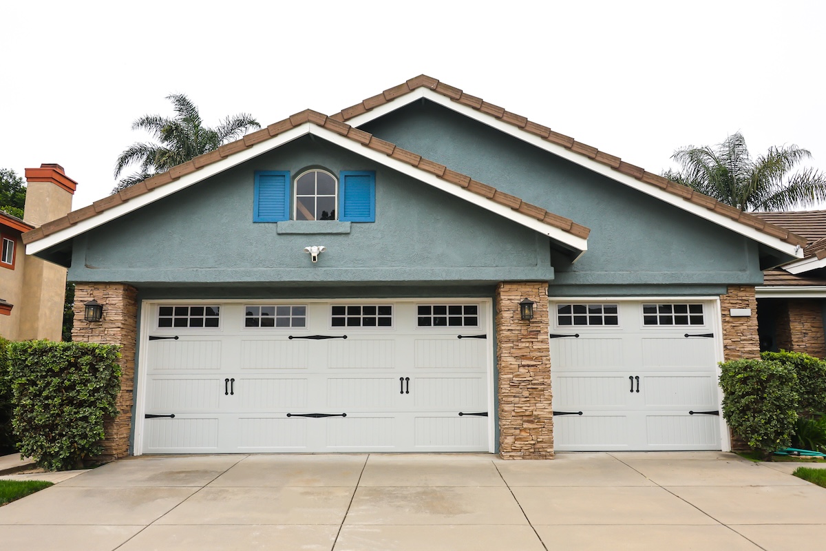 A home with white garage doors with accents and windows.