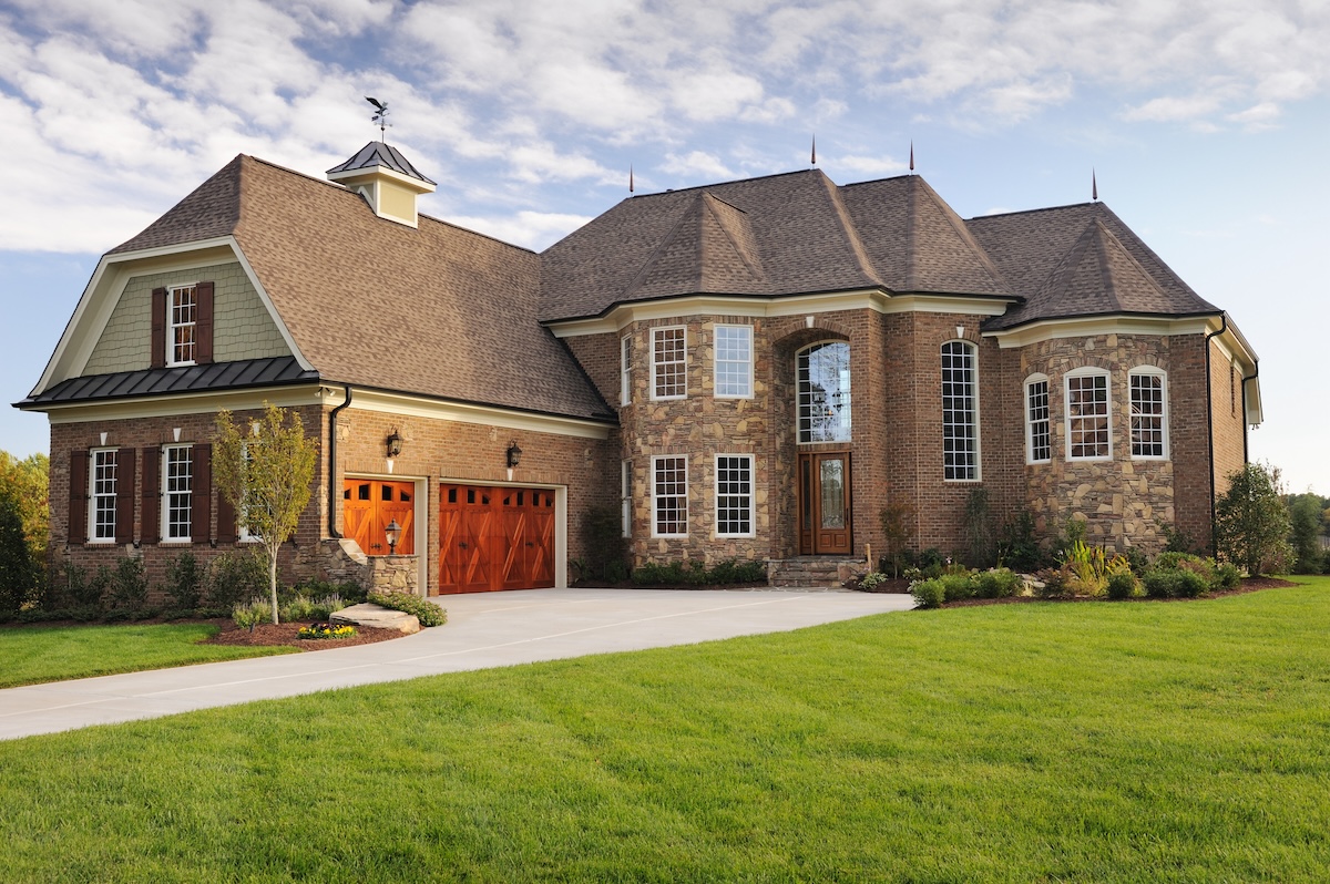 A large brick home with carriage garage doors.