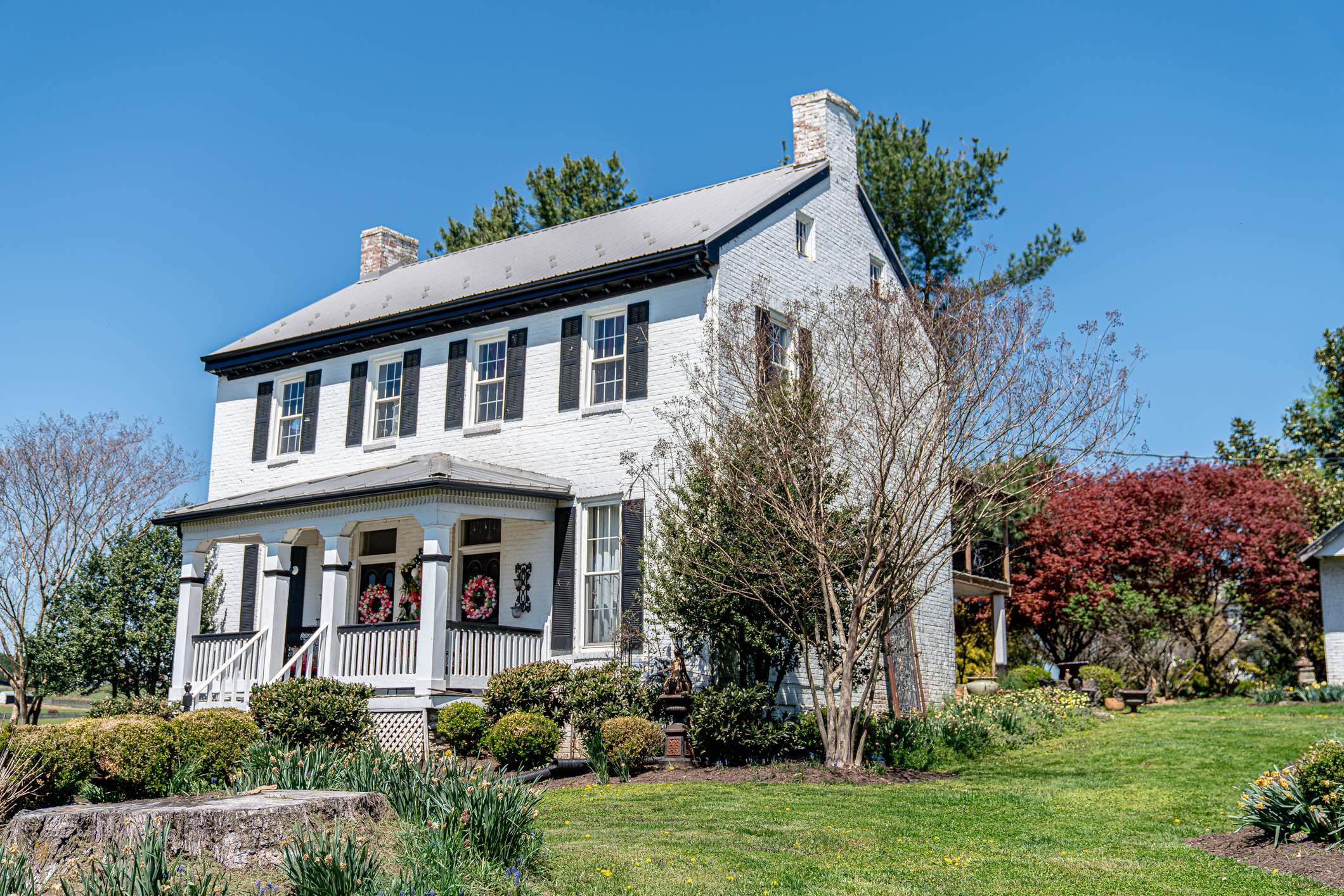 White Colonial-Style Brick Ranch Duplex Home in the springtime.