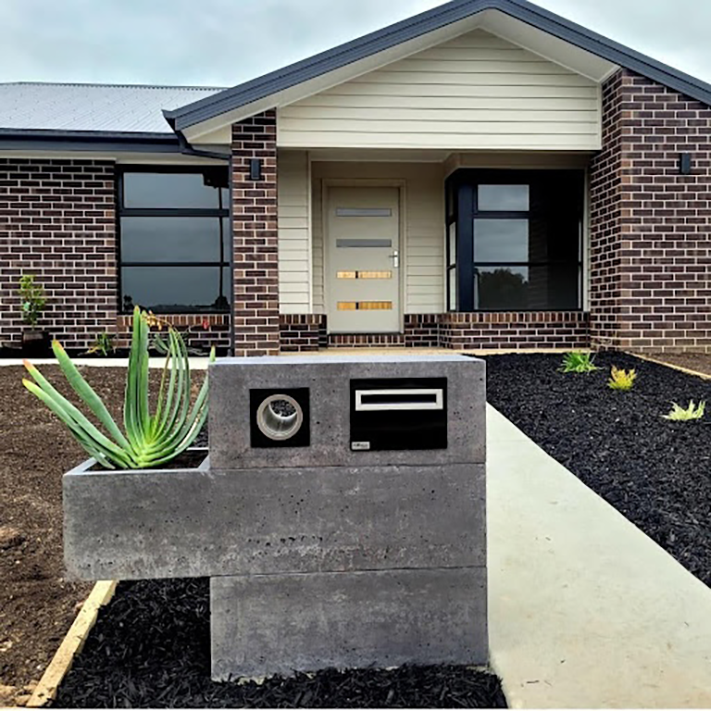 A modern concrete mailbox with succulent planter built-in.