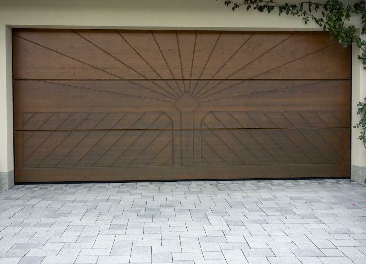 An oak garage door with a sunburst pattern.