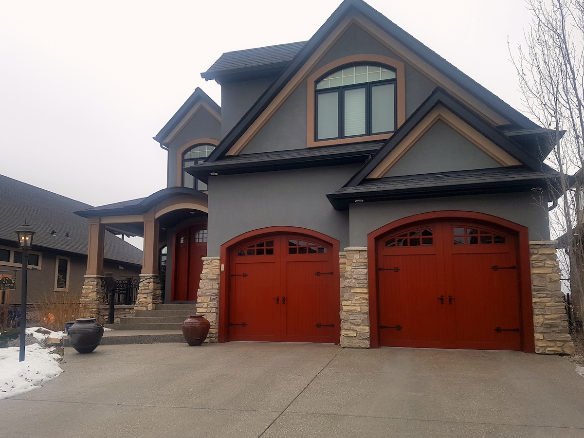 A large modern suburban home with red garage doors.