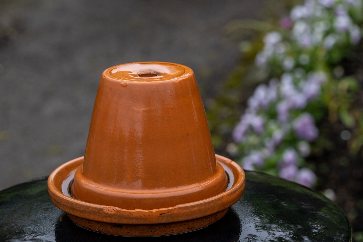 A small water fountain made of two terra-cotta planters.