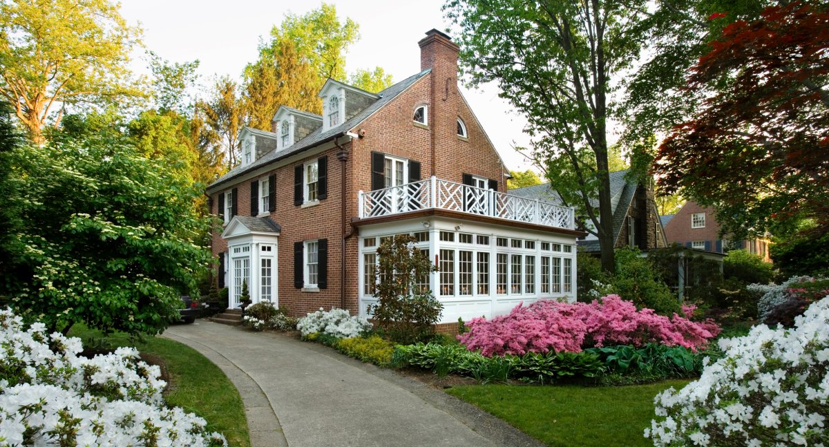 American traditional center hall colonial revival brick home with dormers.